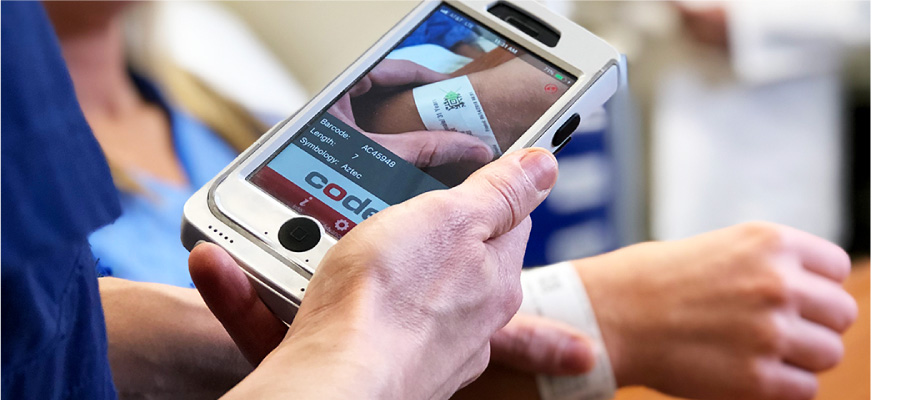 Healthcare worker scanning a patient's wristband at the bedside